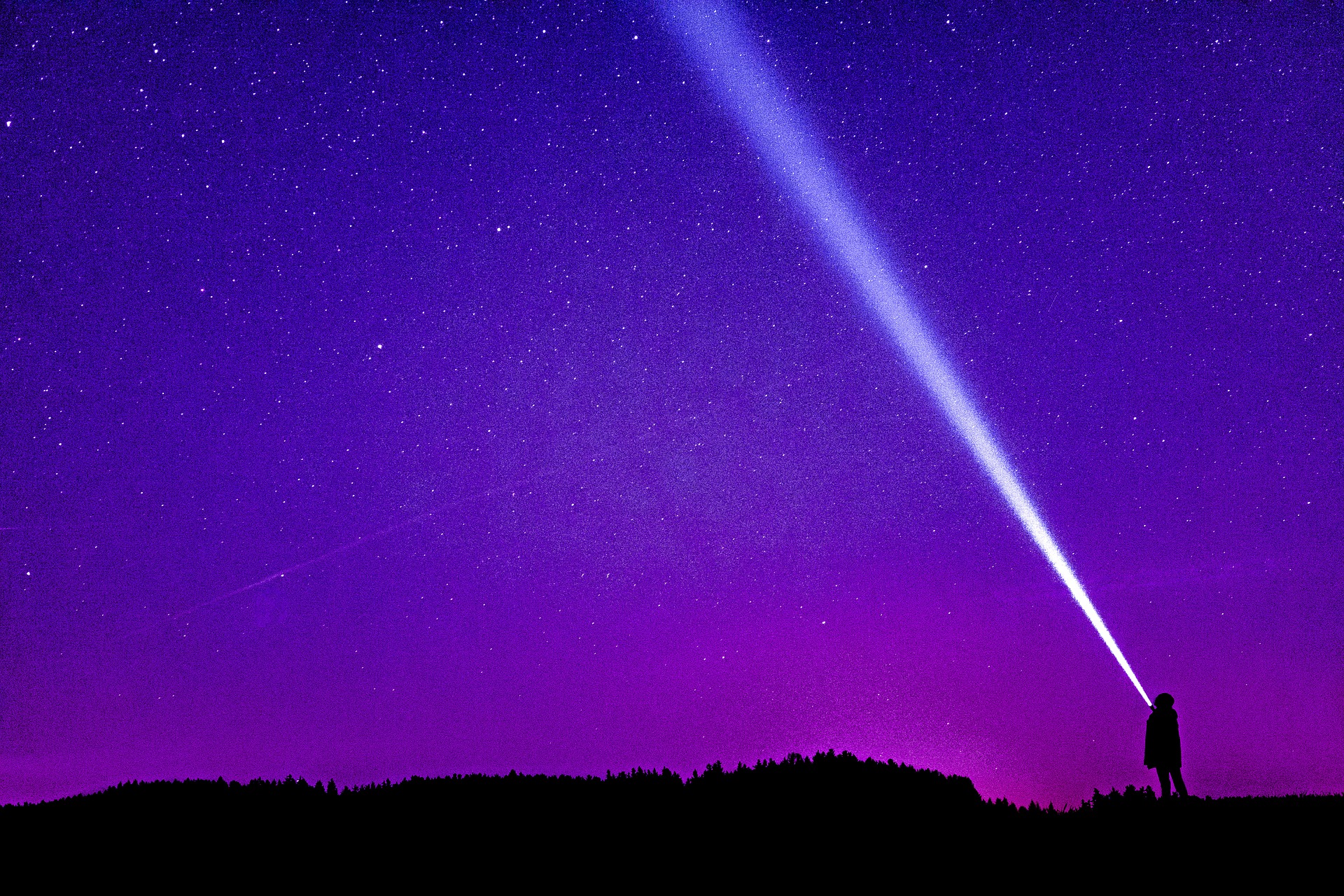 A purple and pink night sky with a silhouette of a person holding a flashlight, the beam stretches across the sky